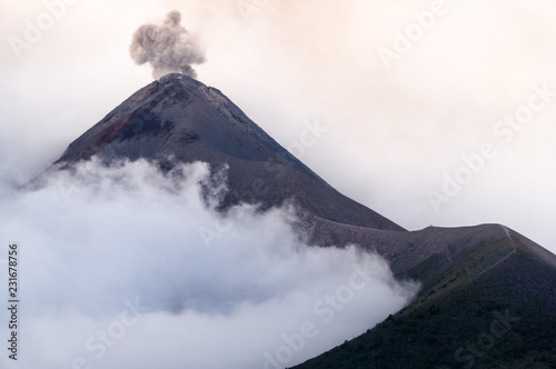 Eruption of volcano Fuego in cloudy and misty weather. Black and white photo.