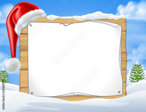 A Christmas sign with a Santa Claus hat in a winter snow landscape scene 