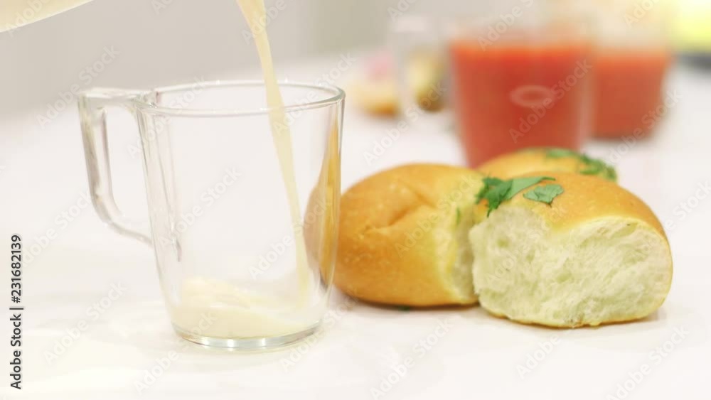 milk is poured into a glass on white desk milk is poured into a glass on white desk