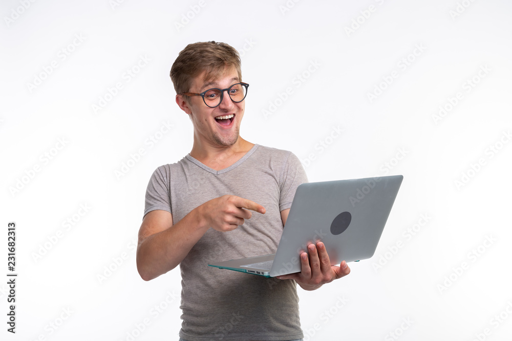 Emotions, education and people concept -a young handsome man looking at netbook and laughing Emotions, education and people concept -a young handsome man looking at netbook and laughing