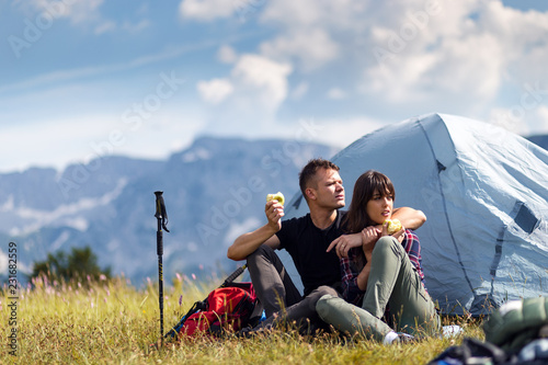 Happy couple of backpackers enjoying while camping at mountain