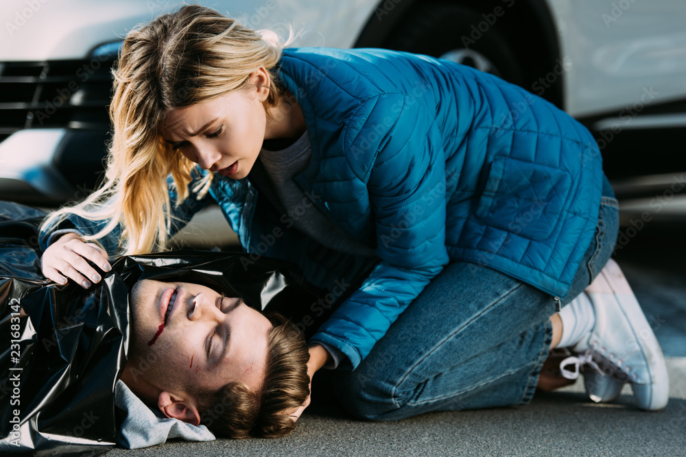 young woman crying above dead man on road after traffic accident Stock  Photo