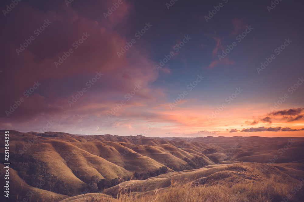Rainy clouds, sunset sky, hills. Indonesia. Spectacular scene the bright sunset sky over the valley. Sumba. Perfect background for the different kinds of the collages and illustrations.