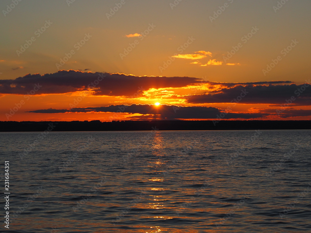 Sunset. On the big river. Coast. Beautiful clouds. Summer. Russia, Ural, Perm region Sunset. On the big river. Coast. Beautiful clouds. Summer. Russia, Ural, Perm region