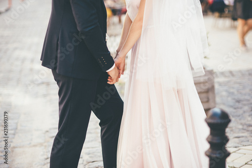 Wedding couple is holding their hands and walking close up