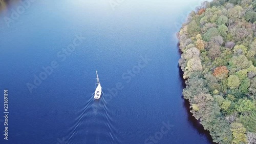 Flying through the Great Glen above Loch Oich towards Loch Ness behind a white motor yacht in the scottish highlands - United Kingdom photo