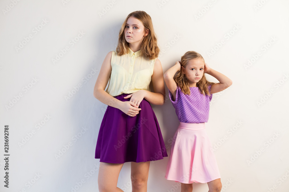 two fashionable girls sisters in beautiful clothes portrait two fashionable girls sisters in beautiful clothes portrait