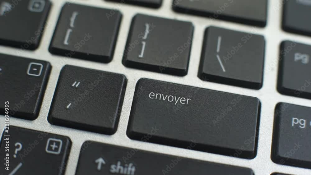 Send in French button on computer keyboard, female hand fingers press key Send in French button on computer keyboard, female hand fingers press key