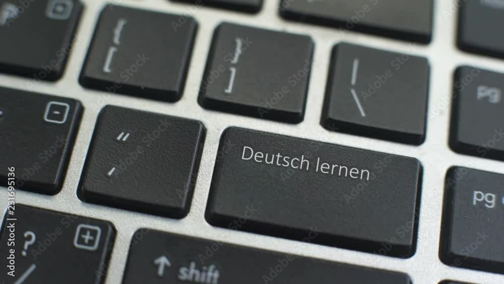 Learn German button on computer keyboard, female hand fingers press key Learn German button on computer keyboard, female hand fingers press key