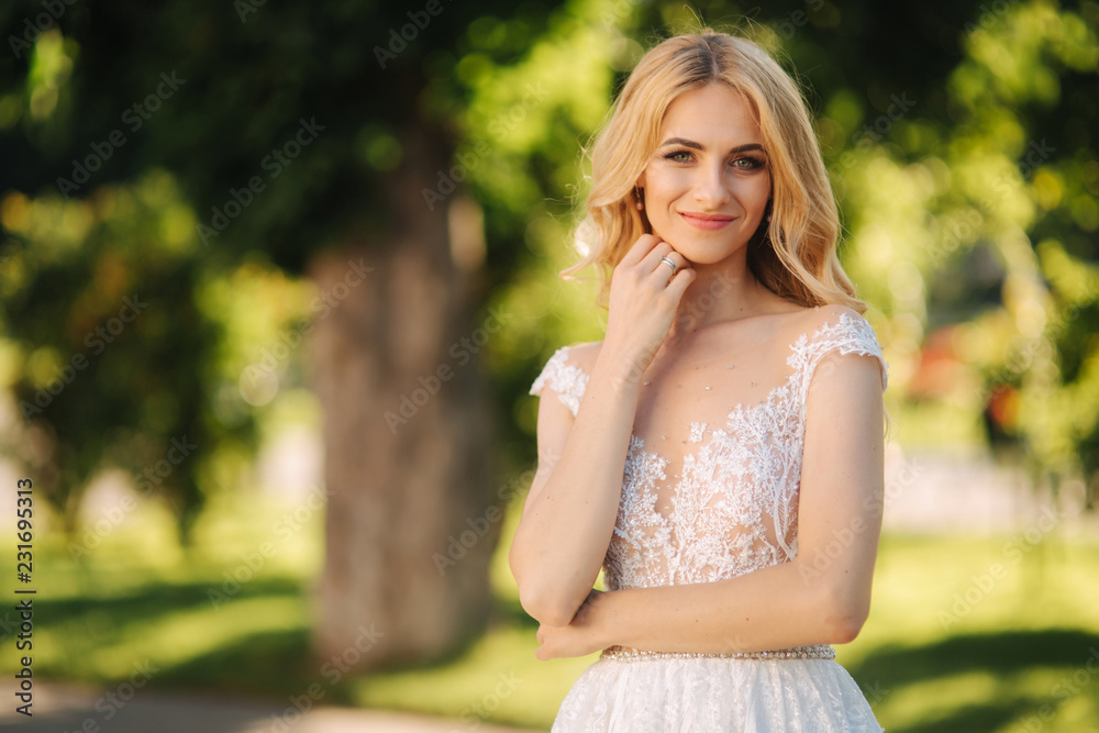 Young bride stand in the park fron of green background Young bride stand in the park fron of green background