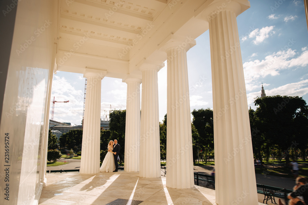 Wedding in greece. Groom and bride stand by the big column