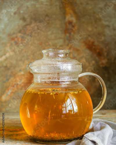 tea in a transparent teapot on the table (herbal tea is brewed). top view.