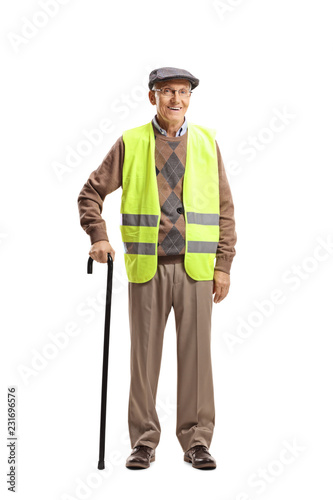Elderly man standing with a cane and wearing safety vest