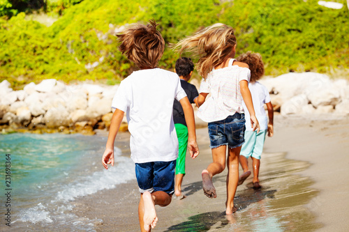 Kids running away along sandy beach in summer © Sergey Novikov