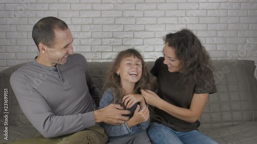 Funny family. Parents tickle the child.