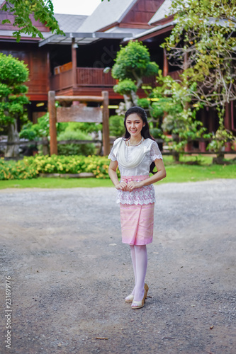 woman in Thai traditional dress at wooden house