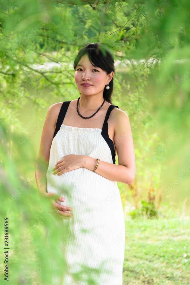 Happy pregnant woman smiles and hugs her belly outdoor Happy pregnant woman smiles and hugs her belly outdoor
