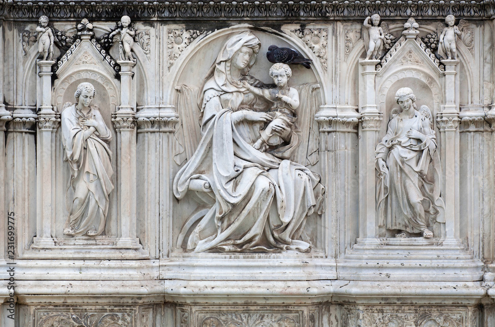 Beautiful sculptures of Mother of God and angels on front of the 15th century fountain Fonte Gaia in Siena, Italy. UNESCO World Heritage Site