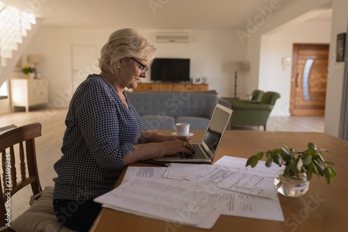 Senior woman using laptop at home photo