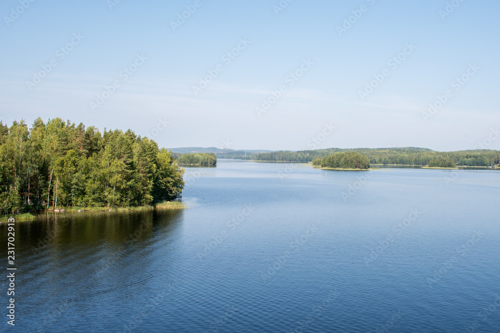 weite Seenlandschaft mit blauem Wasser und grünen Inseln weite Seenlandschaft mit blauem Wasser und grünen Inseln