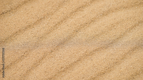 Diagonal waves of sand. Sandy texture background.