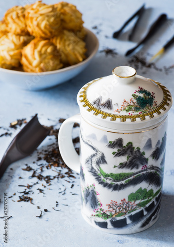 A teacup with ‘Great wall’ design, biscuits, tea, on delicate background