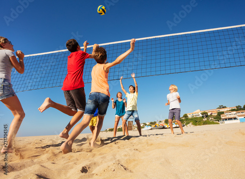 Boys and girls playing volleyball on the beach