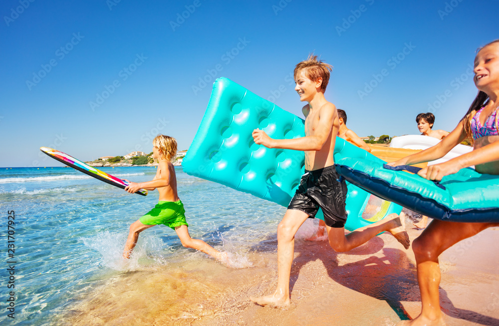 Fototapeta premium Happy teenagers running into the sea in summer