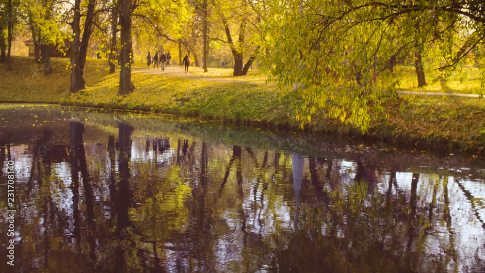 Autumn landscape, lake in the park, unrecognizable people on the background. Autumn landscape, lake in the park, unrecognizable people on the background.