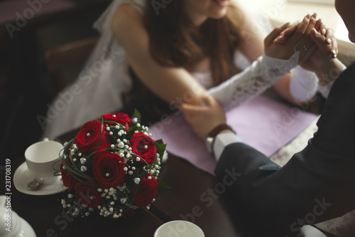 Wedding bouquet on the cafe table during the tea-time of the newlyweds.