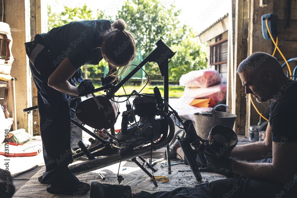 Mechanic repairing motorbike in garage Mechanic repairing motorbike in garage