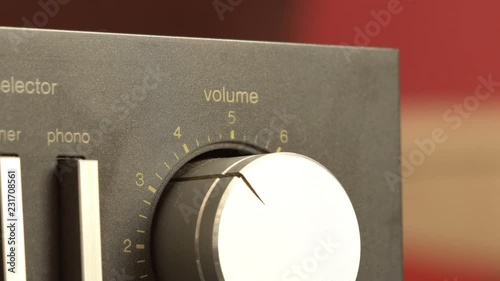 Turning up the volume up to the maximum, closeup of a hand turning the volume dial on a vintage stereo