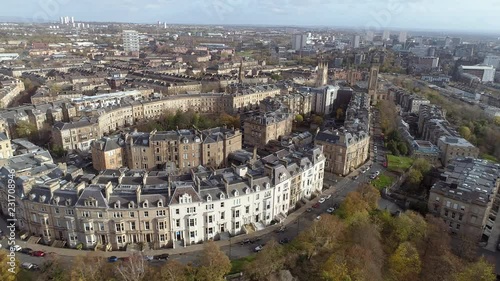 Aerial footage over Kelvingrove Park of the cityscape of Glasgow on a bright early winter’s day. Flying away from the elegant buildings of Park Circus. photo