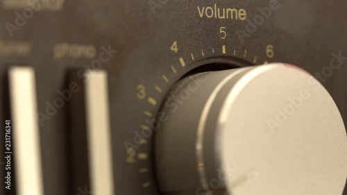 Volume knob turning up and down, fingers shot close up adjusting volume on a classic hi-fi stereo receiver