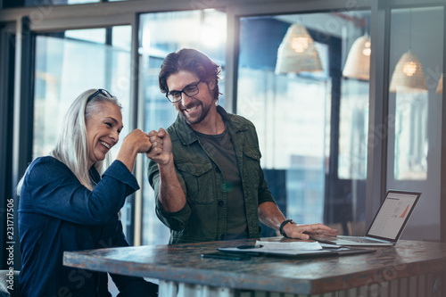 Canvas Print Business colleagues making a fist bump at office