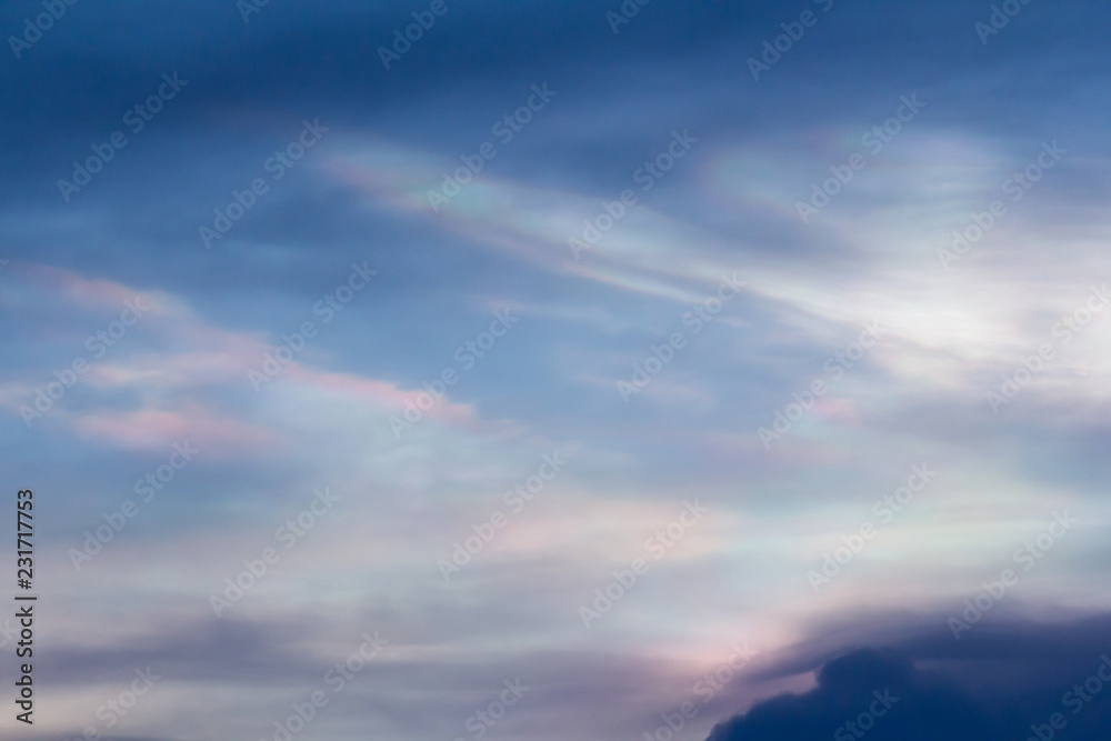 Cloud iridescence background and texture or irisation phenomenon effect, polar stratospheric clouds on blue sky.