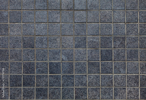Surface of small, dark grey granite tiles