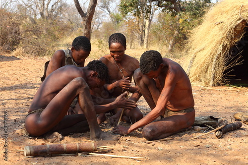 Buschmänner in Namibia beim Feuer machen photo