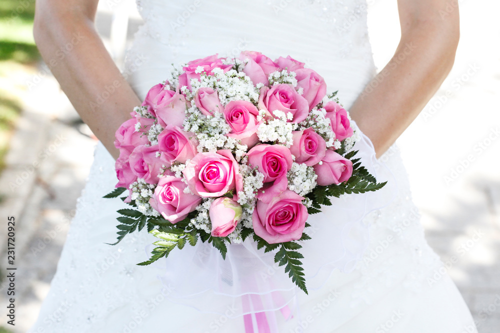 Bouquet di colore bianco e rosa  shocking tenuto in mano  da una sposa