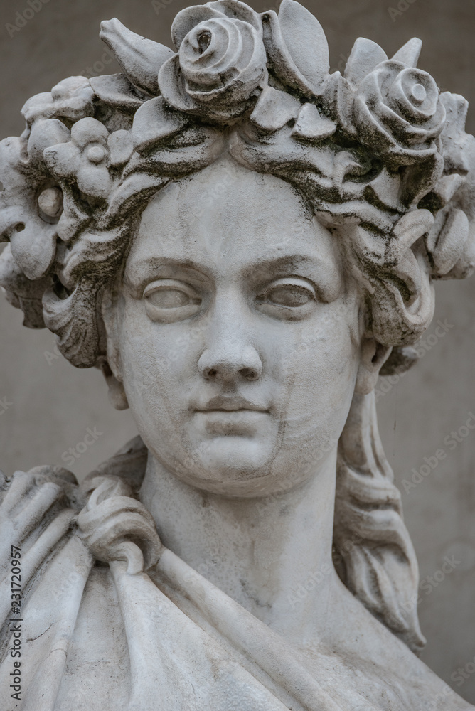Statue of sensual busty and puffy renaissance era woman in circlet of flowers, Potsdam, Germany, details, closeup