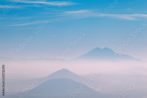 three mountains in the fog on the horizon