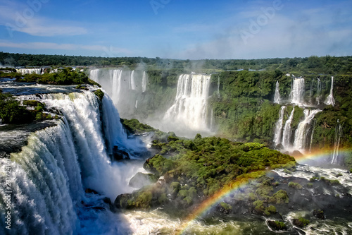 Obraz na plátně Water cascading over the Iguacu falls with rainbow in foreground in Brazil