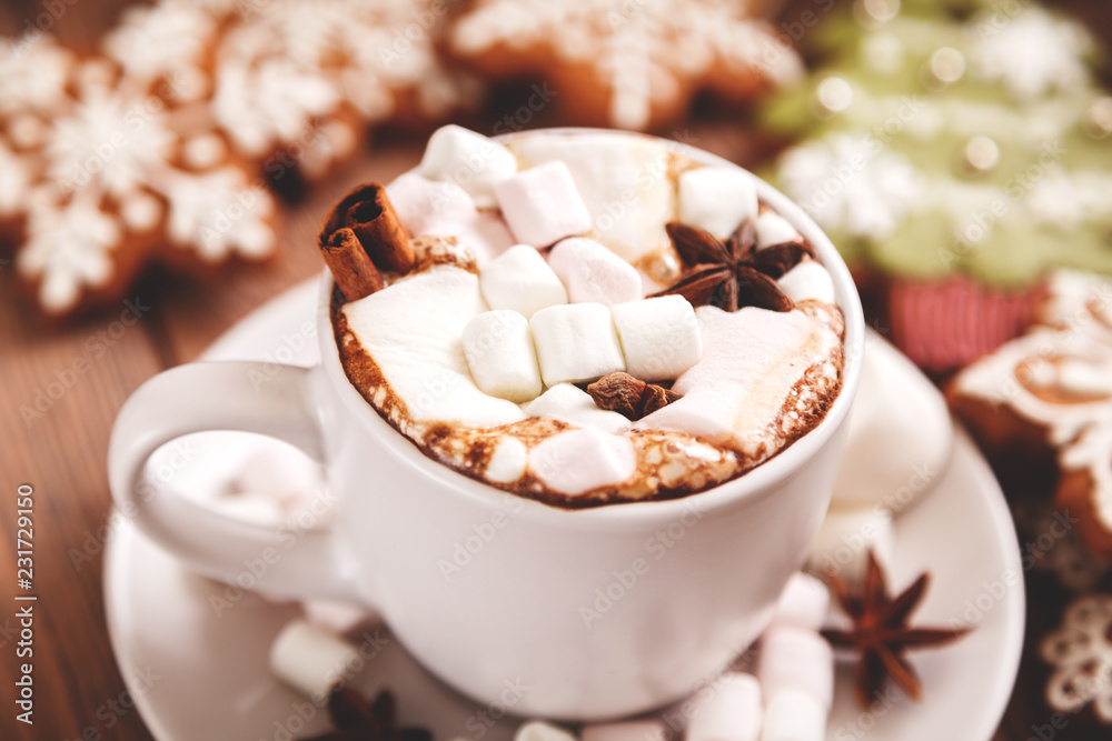 Christmas or new year background. A Cup of festive hot chocolate or cocoa with marshmallows and traditional handmade gingerbread on the table. The concept of advertising cocoa drink. Christmas or new year background. A Cup of festive hot chocolate or cocoa with marshmallows and traditional handmade gingerbread on the table. The concept of advertising cocoa drink.