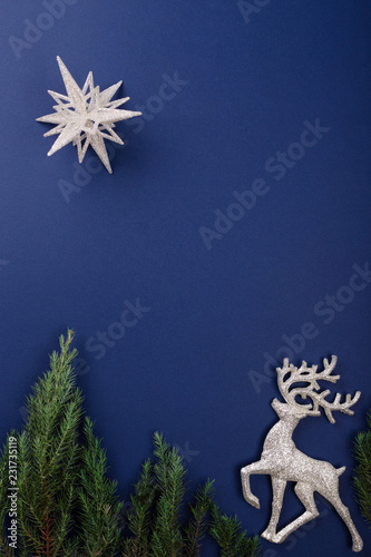 Christmas scene made of silver figurines of reindeer and star on dark blue background. Christmas night concept. Holiday greeting card. photo