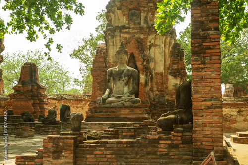 Ruins of Wat Mahathat temple with ancient Buddha sculpture in UNESCO heritage of Ayutthaya historical park, Thailand