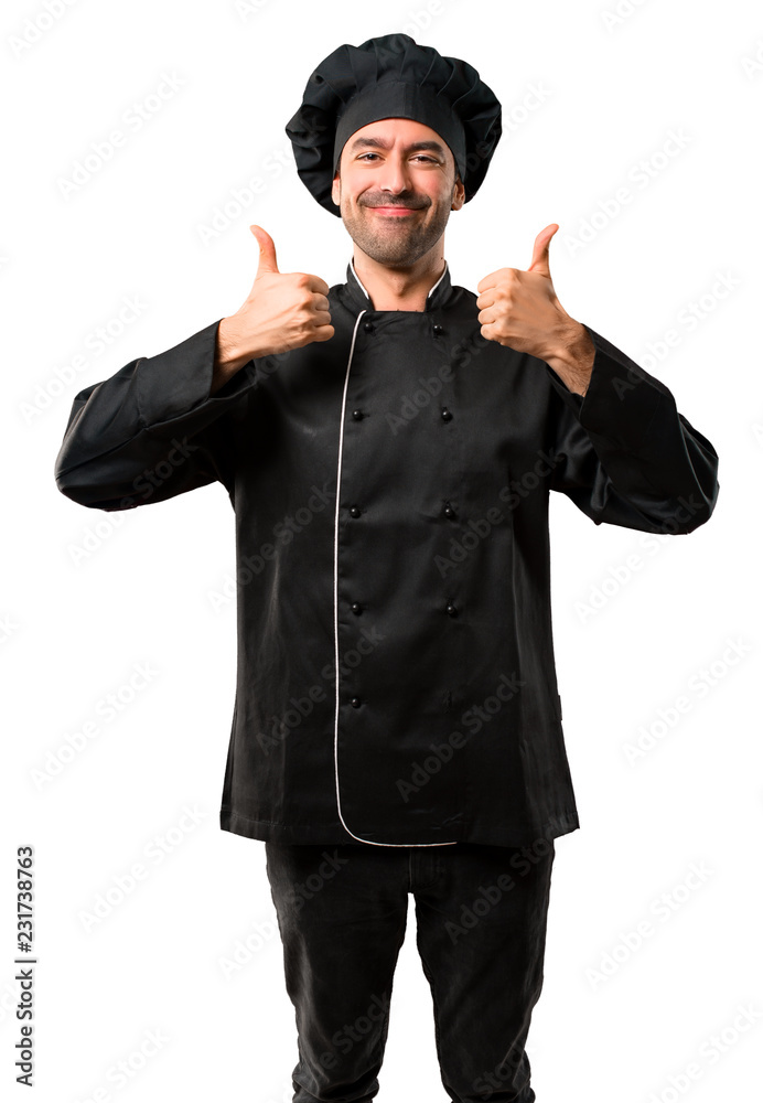 Chef man In black uniform giving a thumbs up gesture and smiling because has had success on isolated white background Chef man In black uniform giving a thumbs up gesture and smiling because has had success on isolated white background