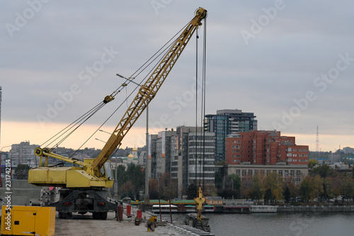 Repair of the bridge in the city, construction of the bridge, crane on the bridge. Lifting equipment. Panorama of the city. 