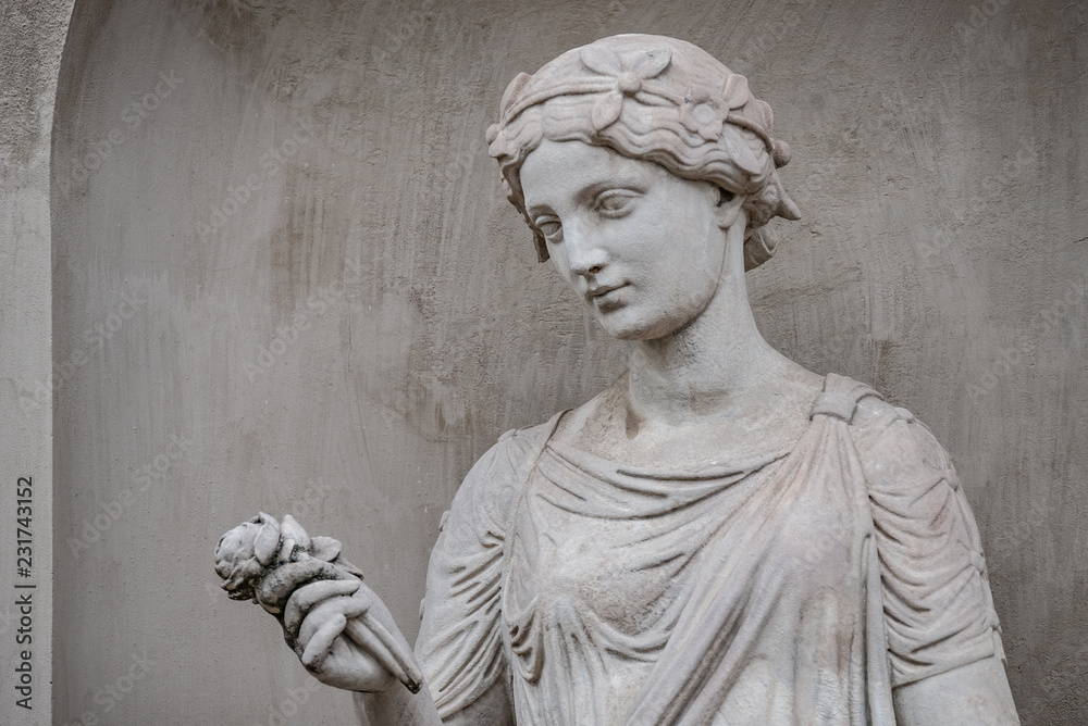 Ancient statue of sensual Greek renaissance era woman with a flower, Potsdam, Germany, details, closeup