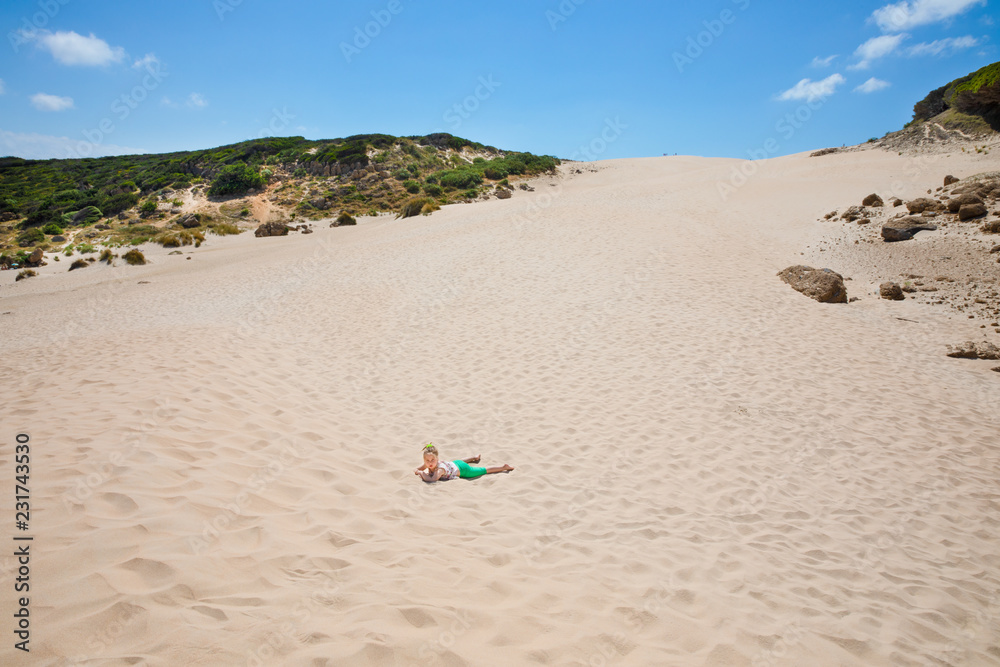 little girl lying on sand under the dune in horizon little girl lying on sand under the dune in horizon