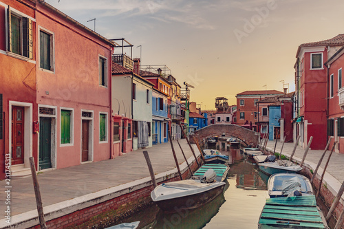Colorful houses and streets by canal on the island of Burano, Venice, Italy, at sunset